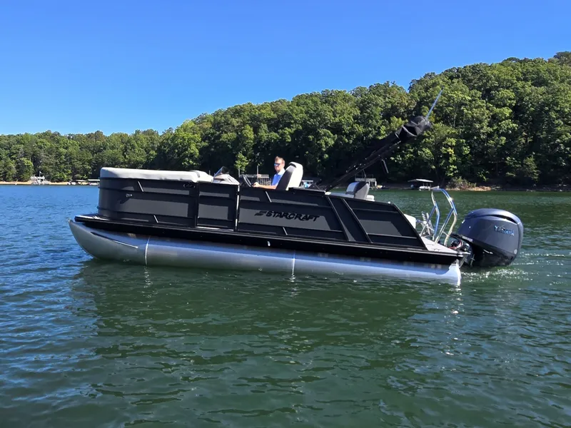 Slide: The Image of A 2027 Starcraft EX 20 Q DH pontoon boat on a calm lake, surrounded by trees. - 35
