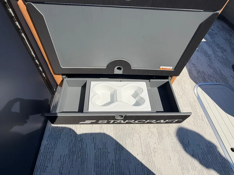 Slide: The Image of An open storage compartment on a Starcraft boat with a molded insert inside. - 23