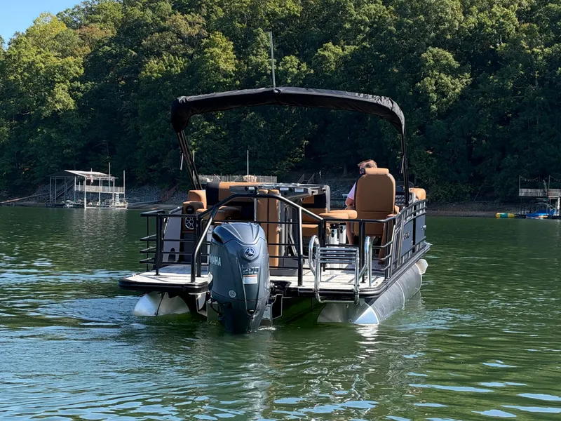 Slide: The Image of A 2027 Starcraft EXS 3 DL pontoon boat on a calm lake with a wooded shoreline. - 44