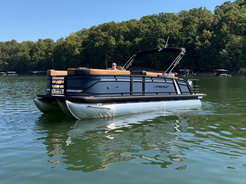 Slide: The Image of A 2027 Starcraft EXS 3 DL pontoon boat on a calm lake. - 1
