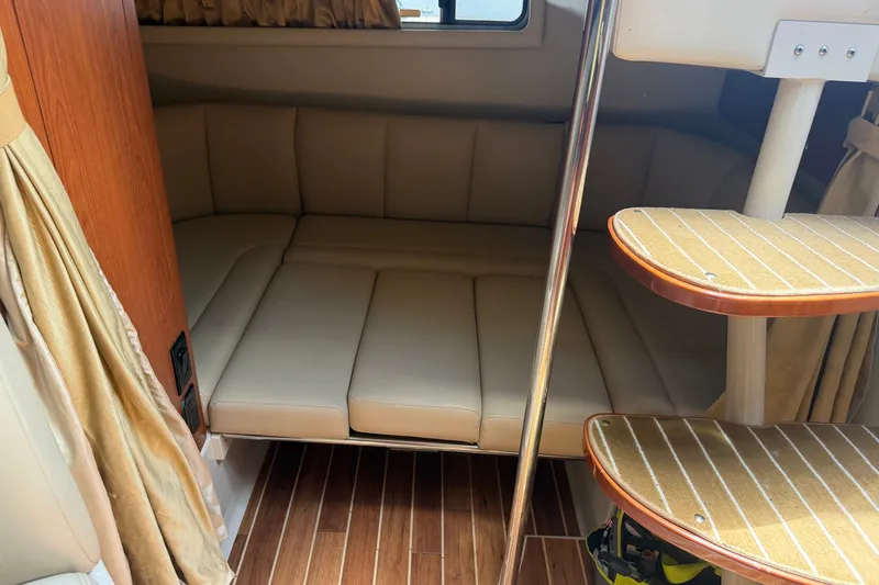 Slide: The Image of Interior of 2004 Chaparral Signature 310 boat with cozy seating and wooden flooring. - 13