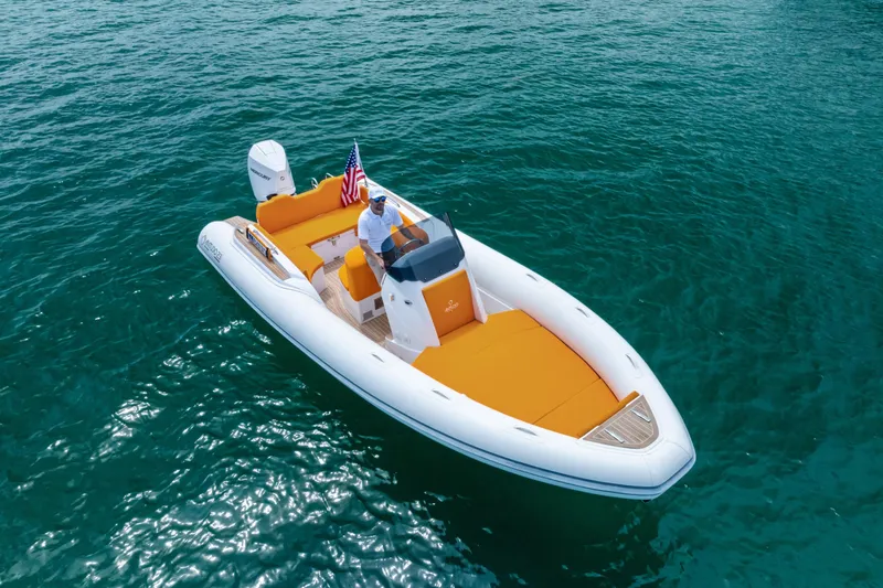 Slide: The Image of 2025 Antudo 23 boat with orange seating on clear blue water. - 4