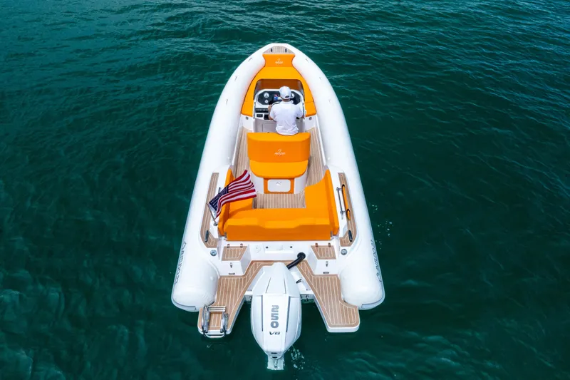 Slide: The Image of Aerial view of 2025 Antudo 23 boat with vibrant orange seating on clear blue water. - 2