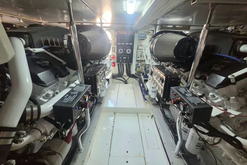 Slide: The Image of Engine room of a 1984 Bertram 54 Convertible yacht, showcasing dual engines and control systems. - 119