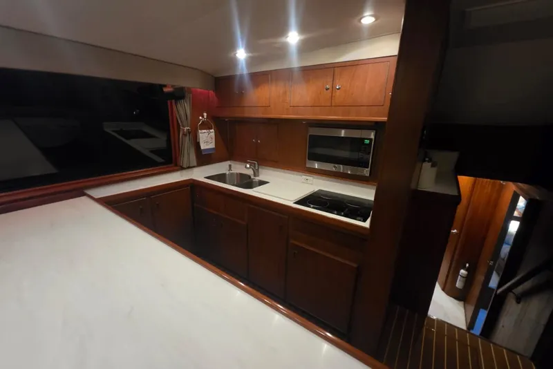 Slide: The Image of Interior of 1984 Bertram 54 Convertible yacht kitchen with wood cabinetry and modern appliances. - 67