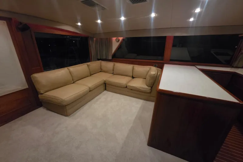 Slide: The Image of Interior of 1984 Bertram 54 Convertible yacht with beige sectional sofa and wooden cabinetry. - 92