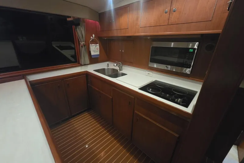 Slide: The Image of 1984 Bertram 54 Convertible yacht kitchen with wooden cabinets and modern appliances. - 73