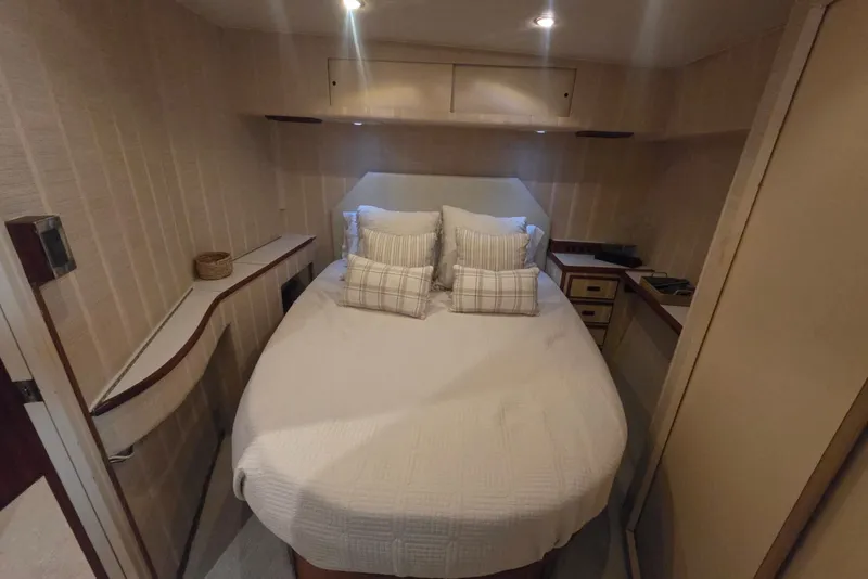 Slide: The Image of Cozy bedroom interior of 1984 Bertram 54 Convertible yacht with plush bedding and ambient lighting. - 64