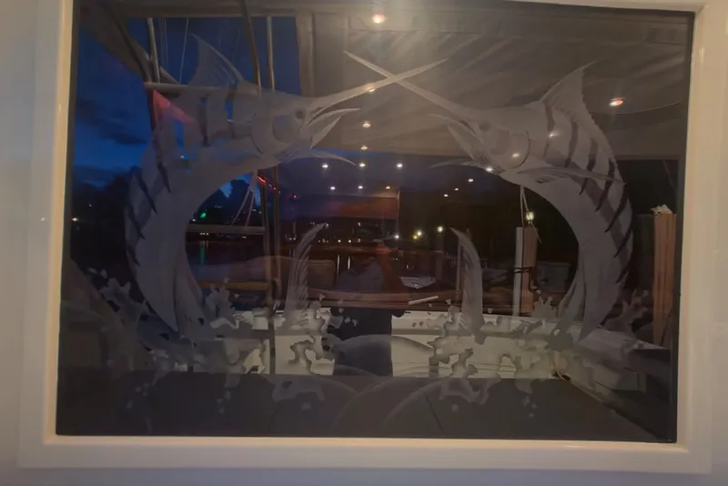 Slide: The Image of Etched glass artwork on 1984 Bertram 54 Convertible yacht, featuring two marlins. - 95