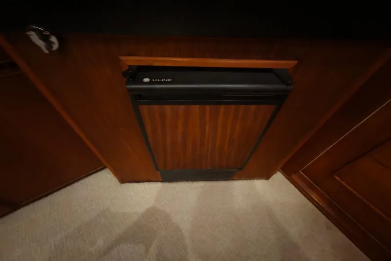 Slide: The Image of U-Line refrigerator in 1984 Bertram 54 Convertible yacht interior, featuring wood paneling. - 96