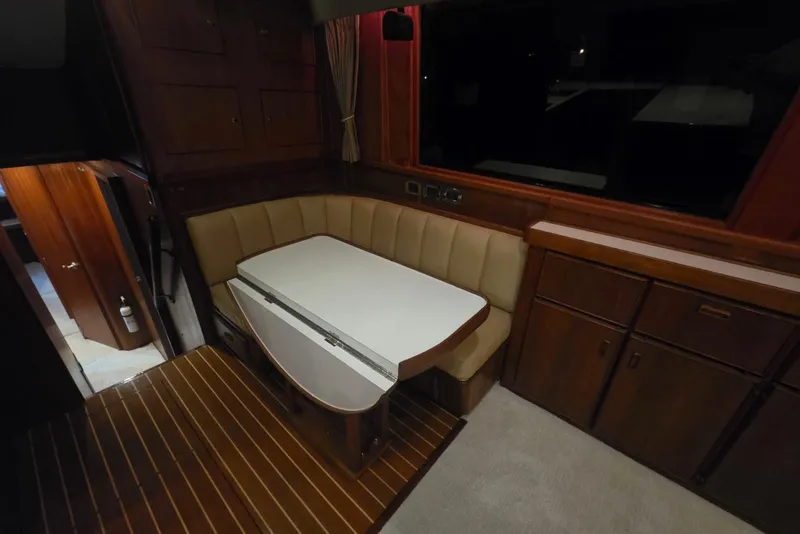 Slide: The Image of Interior of 1984 Bertram 54 Convertible yacht with dining area and wooden cabinetry. - 74