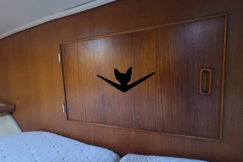 Slide: The Image of Wooden interior of a 1984 Bertram 54 Convertible yacht with a decorative cabinet. - 61
