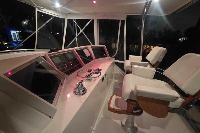 Slide: The Image of Interior of 1984 Bertram 54 Convertible yacht cockpit with steering wheel and control panels. - 55