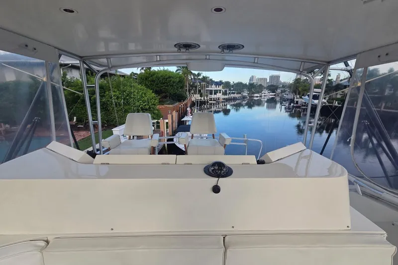 Slide: The Image of 1984 Bertram 54 Convertible yacht interior with marina view, featuring helm and seating area. - 29
