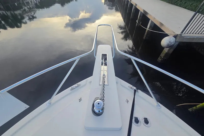 Slide: The Image of Bow view of 1984 Bertram 54 Convertible yacht docked by calm water. - 48