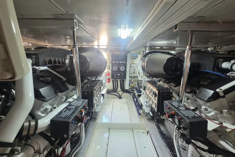 Slide: The Image of Engine room of a 1984 Bertram 54 Convertible yacht, showcasing dual engines and control systems. - 118