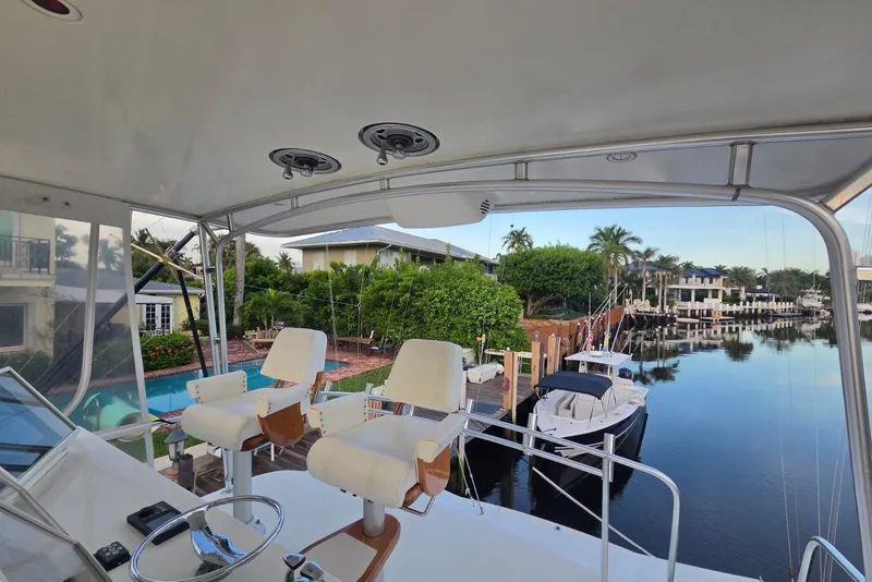 Slide: The Image of Cockpit view from 1984 Bertram 54 Convertible yacht overlooking a serene marina. - 43