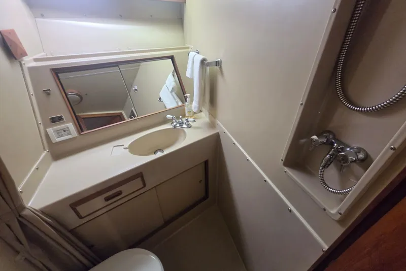 Slide: The Image of Bathroom interior of 1984 Bertram 54 Convertible yacht with sink, mirror, and shower fixtures. - 105