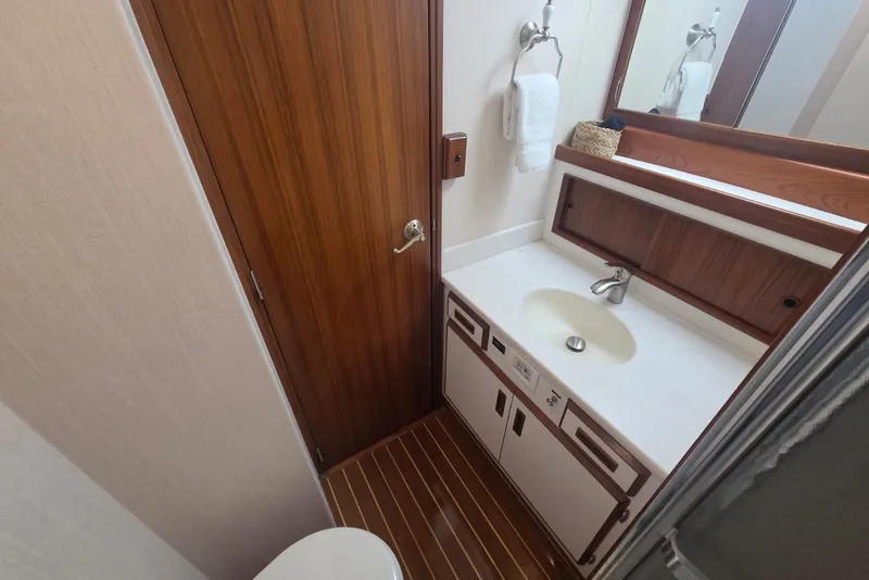 Slide: The Image of Bathroom interior of 1984 Bertram 54 Convertible yacht, featuring wood accents and modern fixtures. - 63