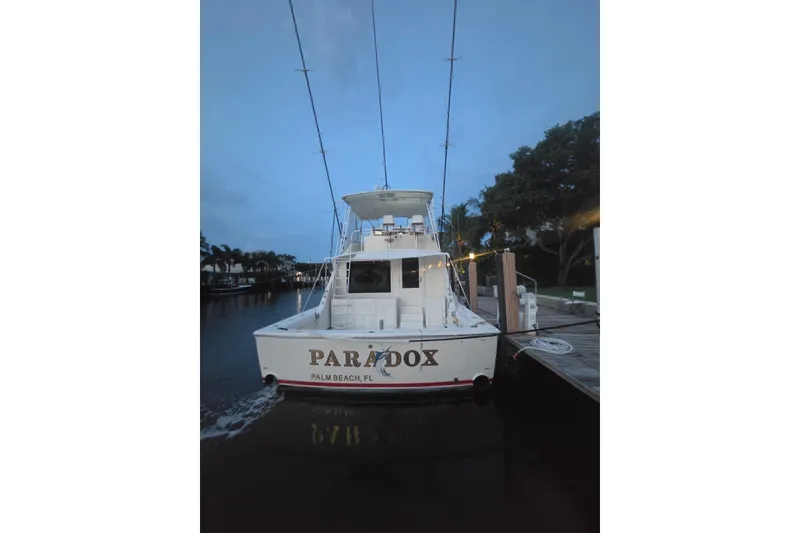 Slide: The Image of 1984 Bertram 54 Convertible yacht docked at Palm Beach marina during twilight. - 99