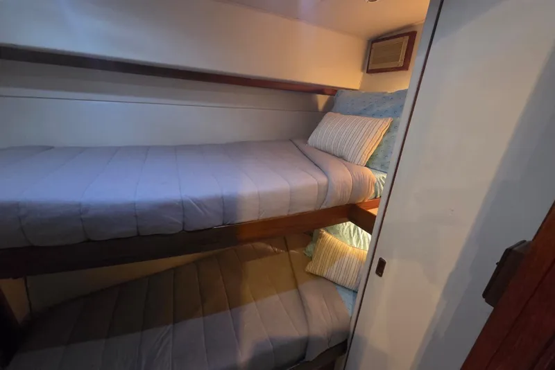 Slide: The Image of Bunk beds in a 1984 Bertram 54 Convertible yacht cabin, featuring cozy bedding. - 72