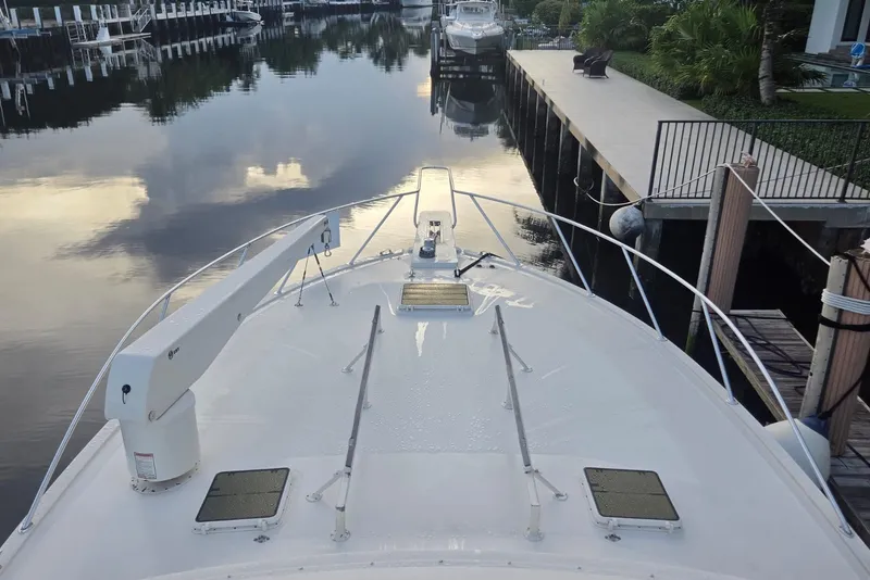 Slide: The Image of 1984 Bertram 54 Convertible yacht docked in a serene marina setting. - 30