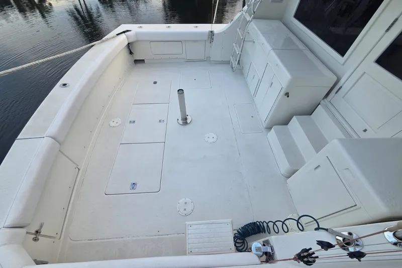 Slide: The Image of Spacious deck of a 1984 Bertram 54 Convertible yacht, featuring storage and seating areas. - 49