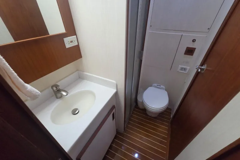 Slide: The Image of 1984 Bertram 54 Convertible yacht bathroom with sink, toilet, and wooden flooring. - 66