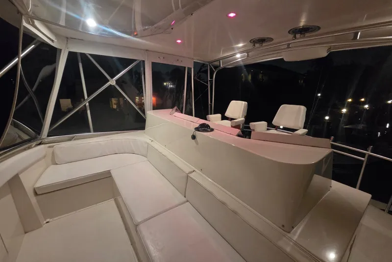 Slide: The Image of Interior of 1984 Bertram 54 Convertible yacht with seating and helm at night. - 57