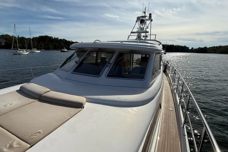 Slide: The Image of 2021 Elling E6 yacht on serene water with sunlit deck and scenic background. - 106