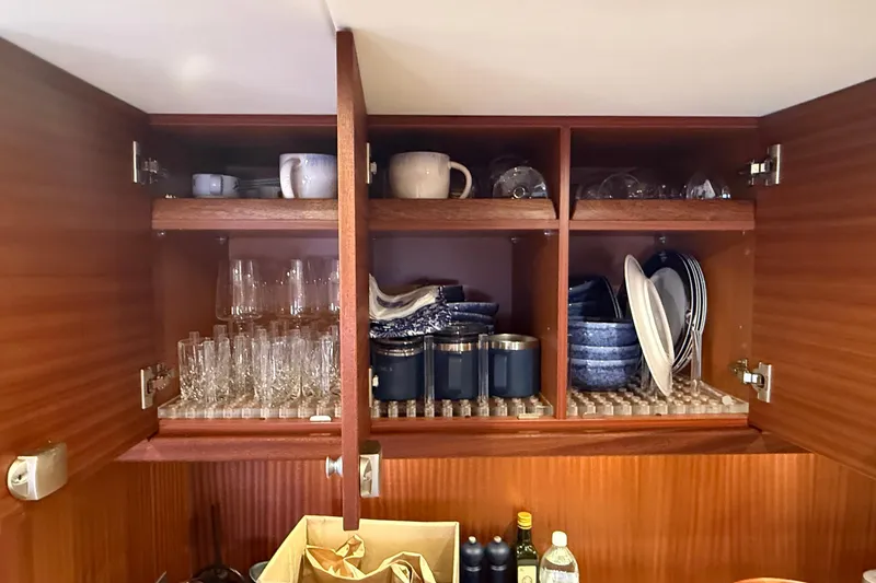 Slide: The Image of Cabinet interior on 2021 Elling E6 yacht, featuring neatly arranged glassware and dishes. - 58