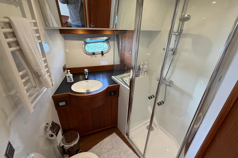 Slide: The Image of Luxurious bathroom in 2021 Elling E6 yacht with shower, sink, and porthole window. - 80