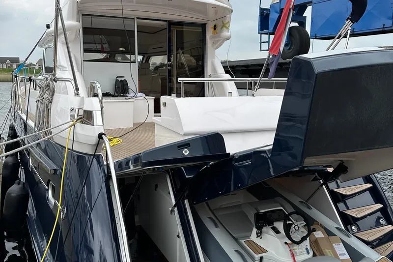 Slide: The Image of 2021 Elling E6 yacht with open deck and visible interior, docked at a marina. - 97