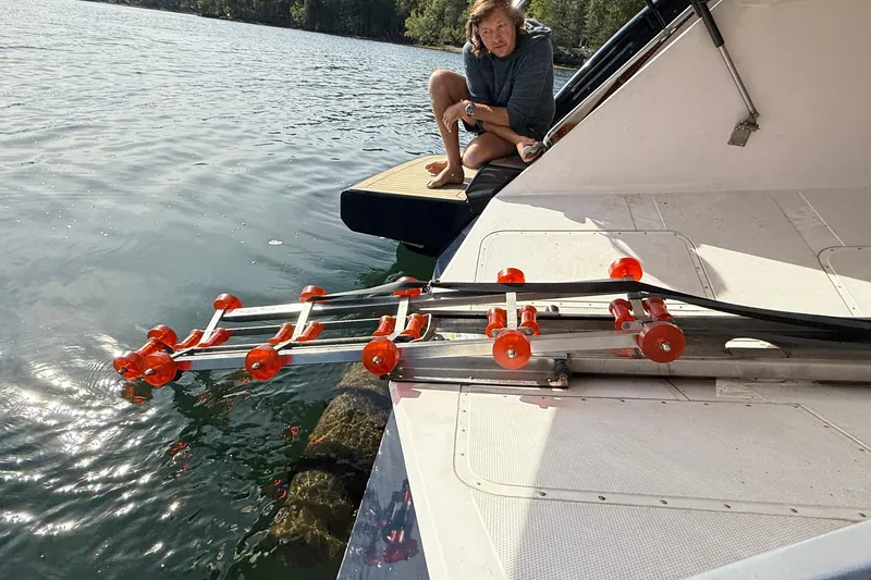 Slide: The Image of Man on Elling E6 yacht with orange roller system, 2021 model, near water. - 95