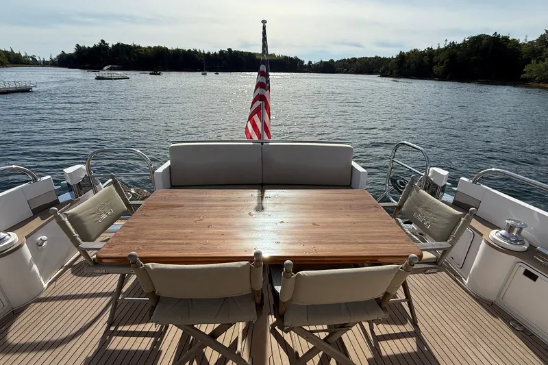 Slide: The Image of Luxury Elling E6 yacht deck with dining table, chairs, and scenic water view, 2021 model. - 15