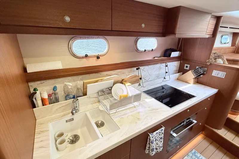 Slide: The Image of Modern kitchen interior on 2021 Elling E6 yacht with marble countertops and wooden cabinetry. - 44
