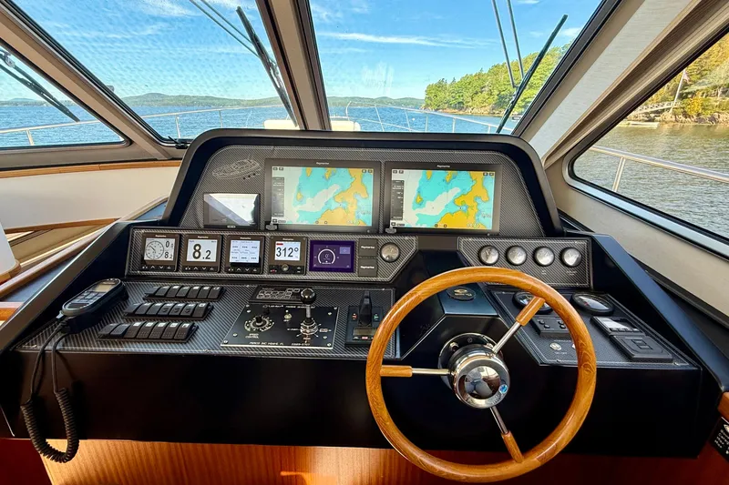 Slide: The Image of Cockpit of 2021 Elling E6 yacht with navigation screens and wooden steering wheel. - 29
