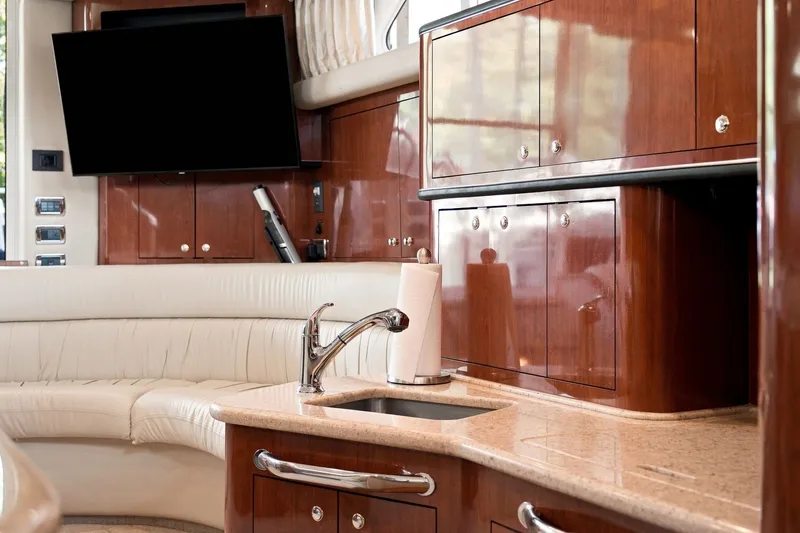 Slide: The Image of Luxurious interior of 2003 Sea Ray 450 Express Bridge with wood cabinetry and modern amenities. - 54