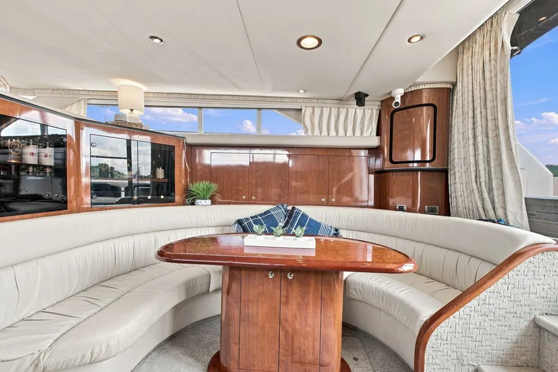 Slide: The Image of Luxurious interior of 2003 Sea Ray 450 Express Bridge yacht with elegant seating and wooden table. - 43