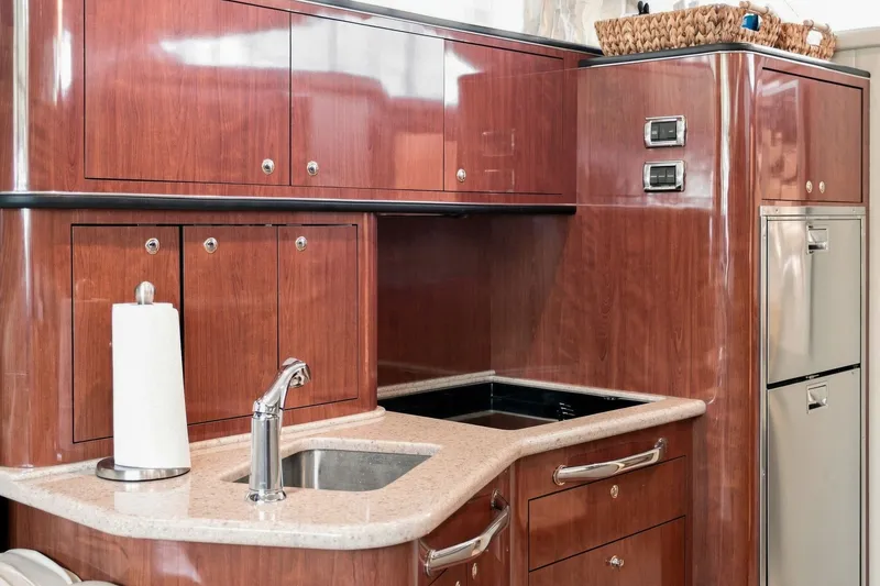 Slide: The Image of Luxurious 2003 Sea Ray 450 Express Bridge yacht kitchen with wood cabinetry and modern appliances. - 58
