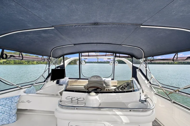Slide: The Image of 2003 Sea Ray 450 Express Bridge helm with canopy, overlooking serene waters. - 17