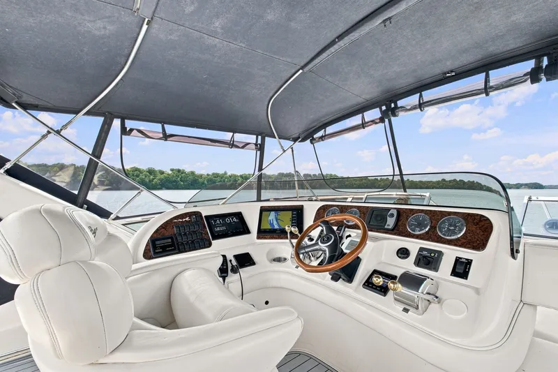 Slide: The Image of Cockpit of 2003 Sea Ray 450 Express Bridge with steering wheel and navigation instruments. - 13