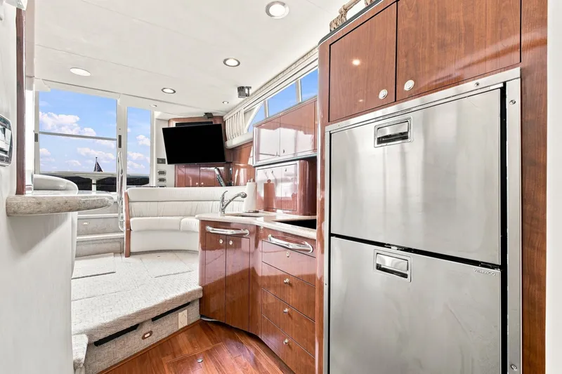 Slide: The Image of Luxurious interior of 2003 Sea Ray 450 Express Bridge yacht with modern kitchen and seating area. - 52