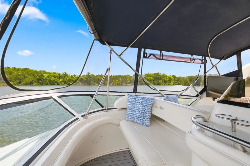 Slide: The Image of 2003 Sea Ray 450 Express Bridge interior with scenic water view and comfortable seating. - 16