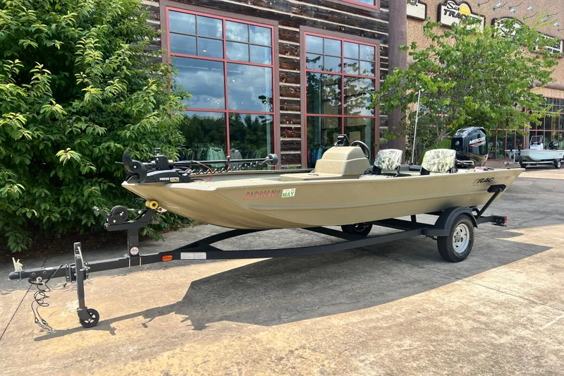 The Image of 2025 Tracker Grizzly 1754 SC boat on trailer, parked outdoors near a building. - 0