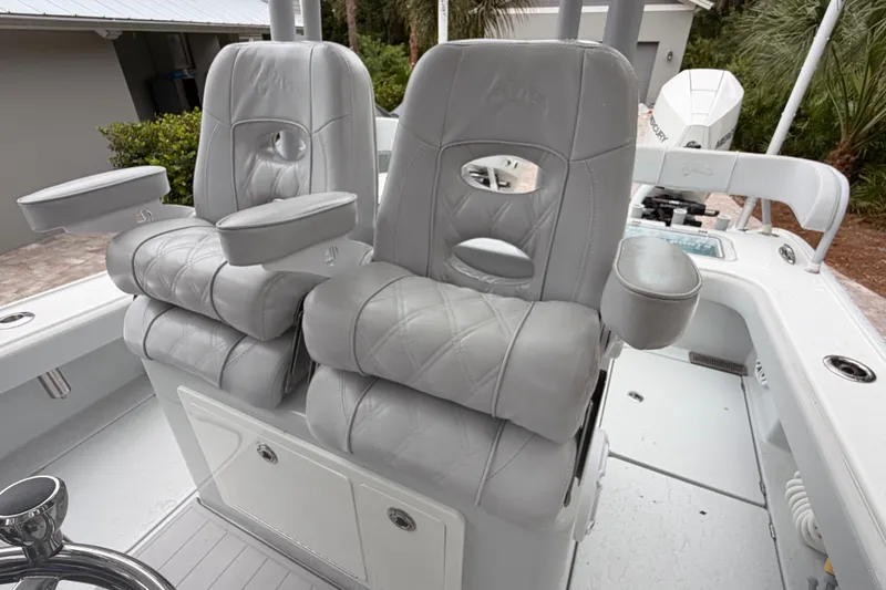 Slide: The Image of Luxurious seating on 2021 Costa Custom Boats 264HC, featuring plush gray upholstery and armrests. - 21