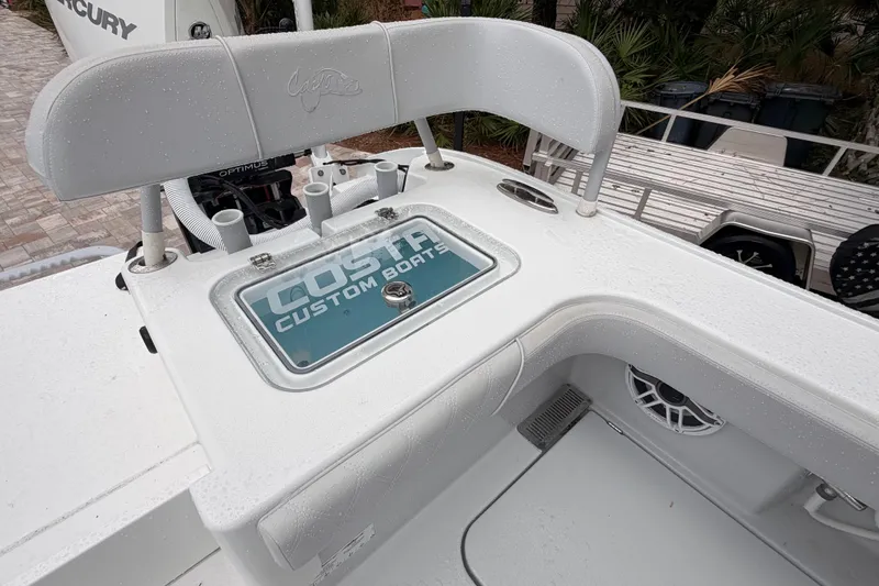 Slide: The Image of 2021 Costa Custom Boats 264HC deck with seating and branded storage compartment. - 23