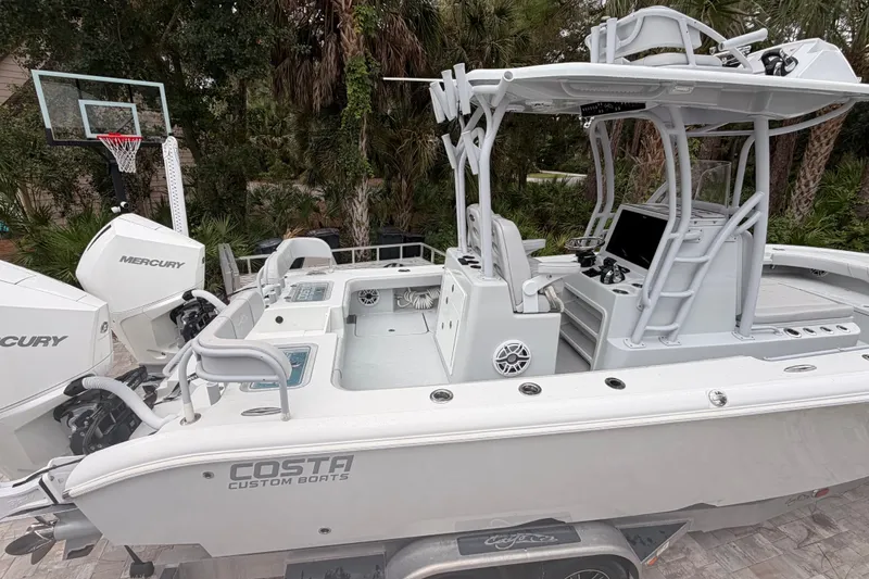 Slide: The Image of 2021 Costa Custom Boats 264HC with dual Mercury engines, parked near a basketball hoop. - 17