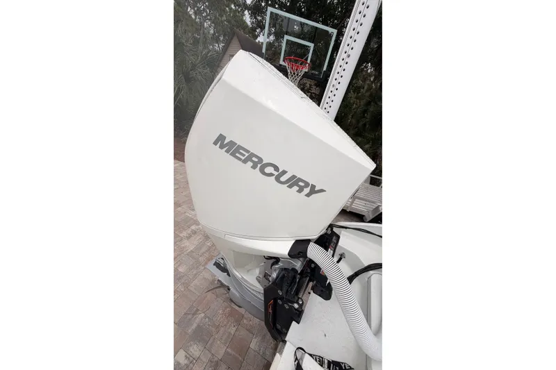 Slide: The Image of Mercury outboard motor on 2021 Costa Custom Boats 264HC, with basketball hoop in background. - 10