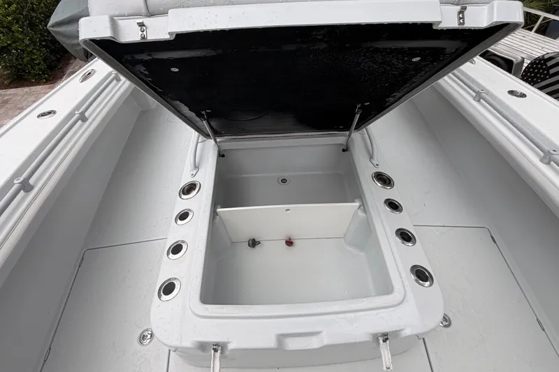 Slide: The Image of Open storage compartment on 2021 Costa Custom Boats 264HC, featuring multiple rod holders. - 16
